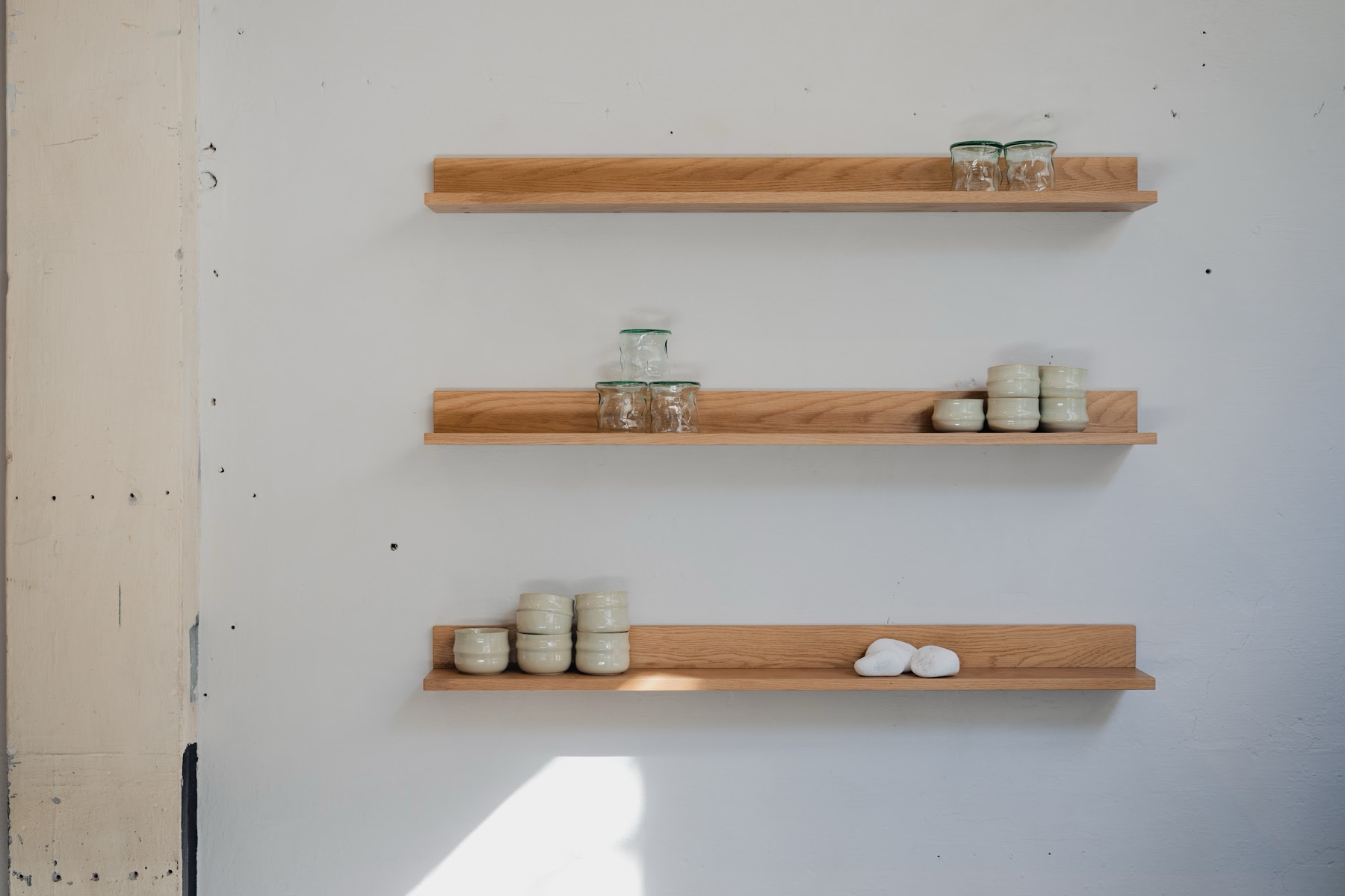 Houten rekken met potten aan de muur